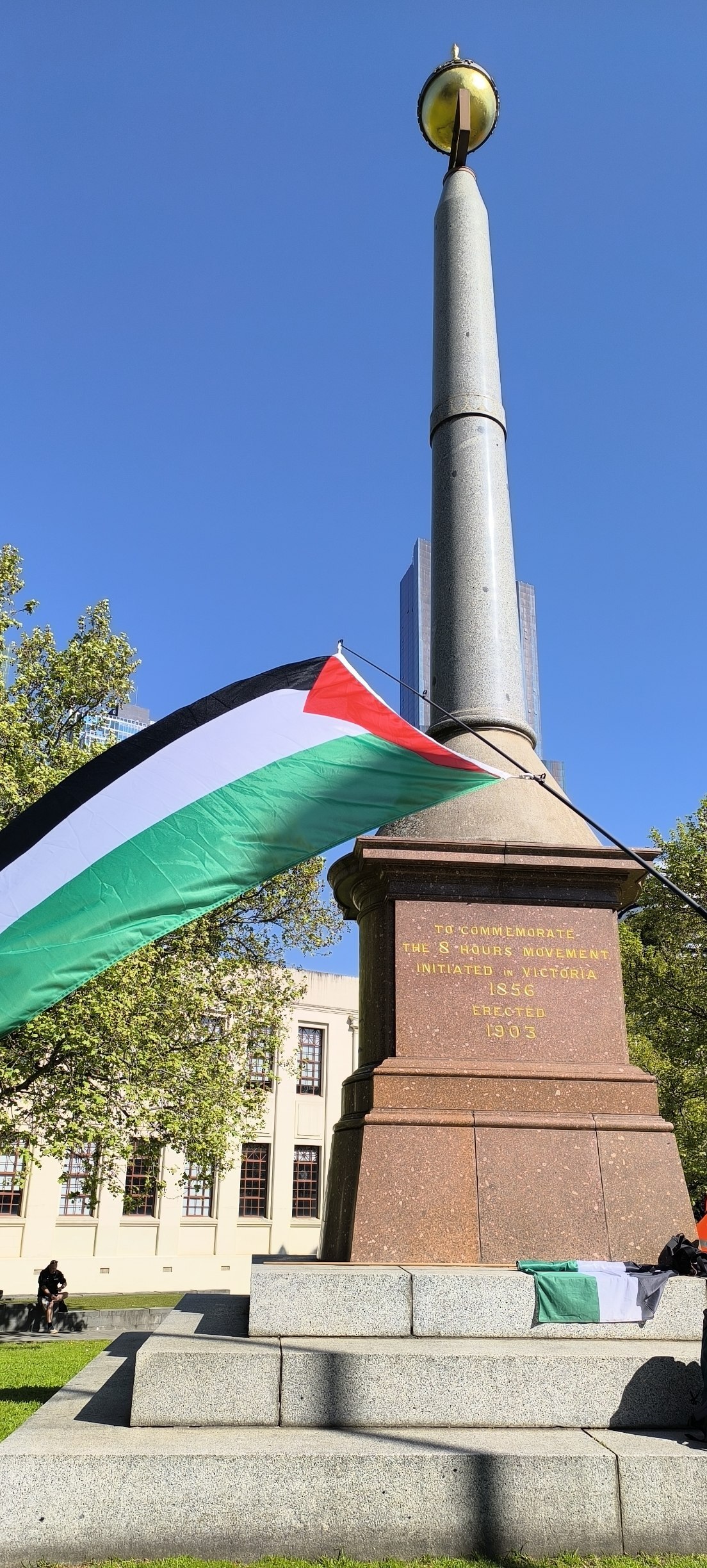 Palestinian flag flies in front of the eight hour monument in Naarm/Melbourne